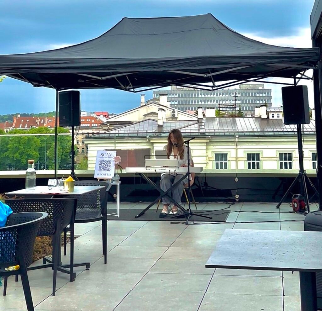Gyvos muzikos pasirodymas po palapine, garso kolonėlės iš abiejų pusių